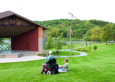 People enjoying the park with the bandshell in the background.