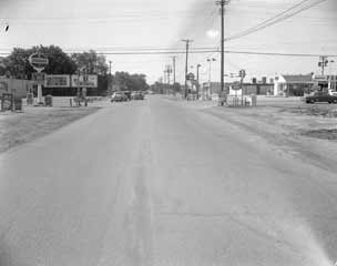 Dismal street scene, couple of cars and a Standard Oil Station.