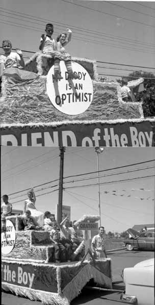 Pretty girl and kids on float wave to the crowd.