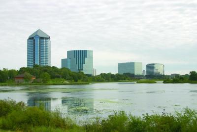 Four office towers with Normandale Lake in foreground.