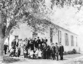 Congregation in front of the church on a sunny day.